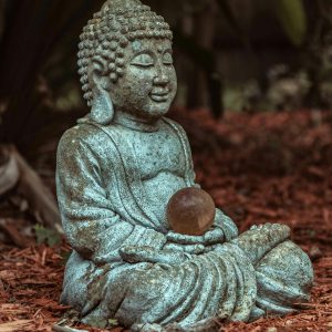 a statue of teh buddha holding a copper globe