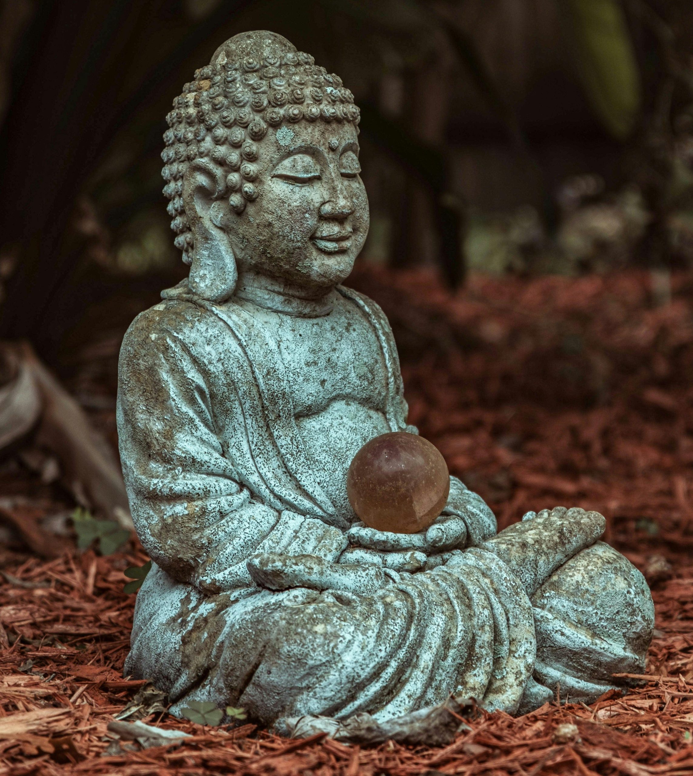 a statue of teh buddha holding a copper globe